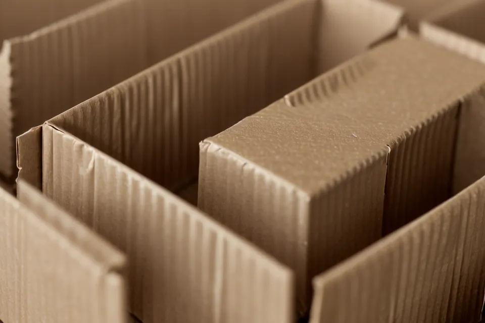 Detalle del grosor de flauta B en una caja de cartón corrugado para envíos seguros de postres.